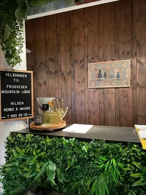 a bench with a sign on a wooden wall at Måsåplassen Friisvegen Mountain Lodge in Ringebu