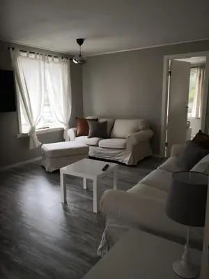 a living room with two couches and a table at Old School på Eidslandet - exclusive apartment in Eidslandet
