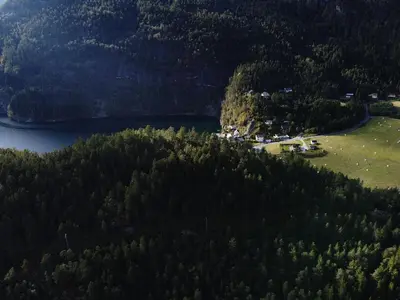 an aerial view of a house on a hill next to a lake at Old School på Eidslandet - exclusive apartment in Eidslandet