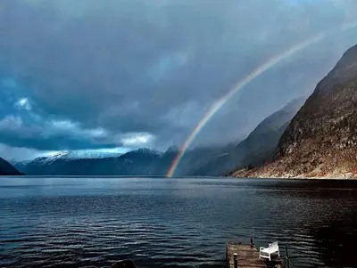 a rainbow in the middle of a lake with mountains at Fjordperlen in Eidfjord