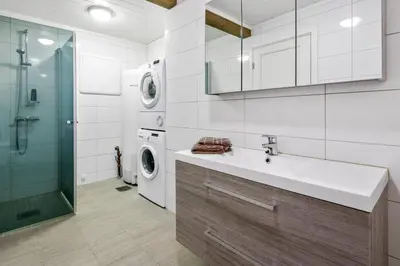a bathroom with a sink and a washing machine at Pudderhytta in Sogndal