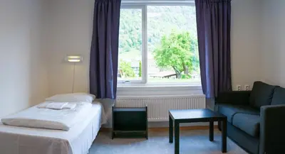 a hotel room with a bed and a couch and a window at Sogndal Bed & Breakfast in Sogndal