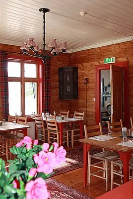 a dining room with tables and chairs and a chandelier at Eidfjord Gjestgiveri in Eidfjord