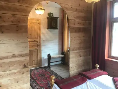 a bedroom with wooden walls and a bed in a room at Eidfjord Gjestgiveri in Eidfjord