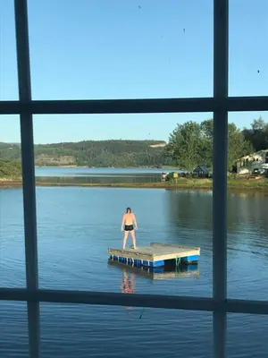 a man standing on a dock in the water at SAGA, unikt badehotell med 5 rom, sauna og badebrygge - Inderøy in Straumen