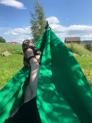 a woman is laying in a green hammock at SAGA, unikt badehotell med 5 rom, sauna og badebrygge - Inderøy in Straumen