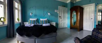 a blue room with a bed with two pillows at Haaheim Gaard in Uggdal