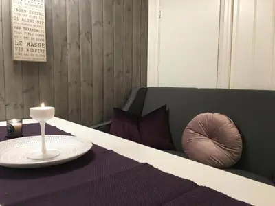 a bed with a table with a candle on it at Kvamseter Lodge - Mountain Apartments in Norheimsund