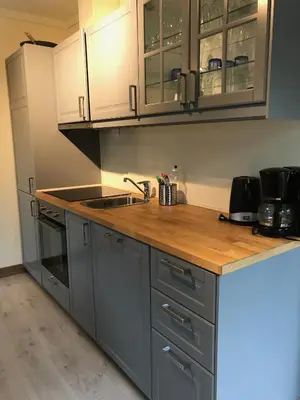 a kitchen with gray cabinets and a wooden counter top at Kvamseter Lodge - Mountain Apartments in Norheimsund