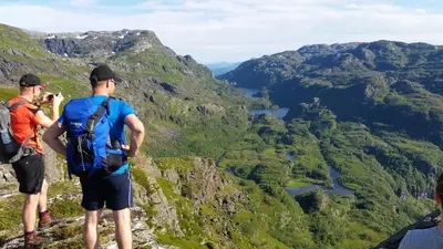 two men standing on the edge of a mountain taking a picture at Etne Hytter in Etnesjøen