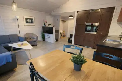 a kitchen and living room with a table and a couch at Etne Hytter in Etnesjøen