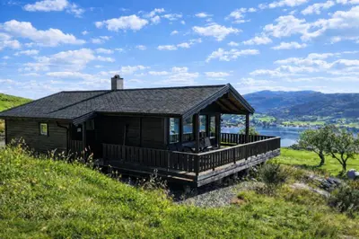 a cabin on a hill with a view of a lake at Etne Hytter in Etnesjøen