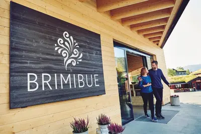 a man and a woman standing in front of a building at BrimiBue Hotel in Lom