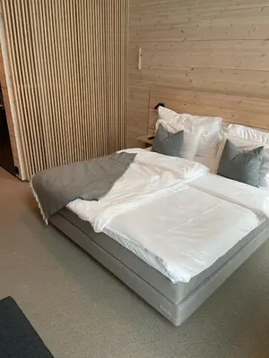 a large bed with white sheets and pillows at BrimiBue Hotel in Lom