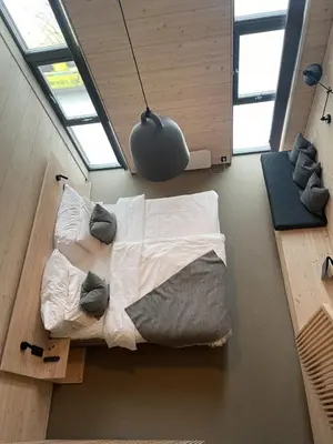 a bedroom with a bed with pillows and a light at BrimiBue Hotel in Lom
