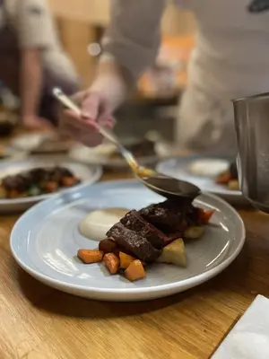 a plate of food with meat and vegetables on a table at BrimiBue Hotel in Lom