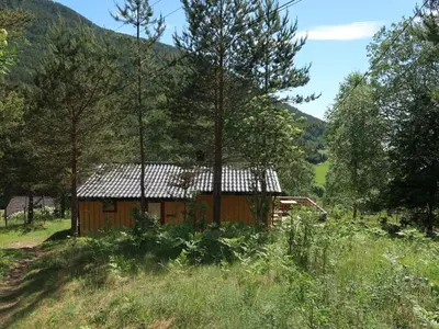 a cabin in the middle of a field with trees at Holiday Home Turken by Interhome in Kaupanger