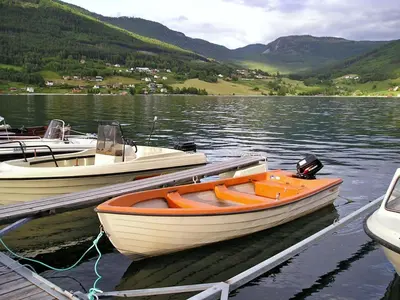 three boats are docked at a dock on a lake at Holiday Home Turken by Interhome in Kaupanger