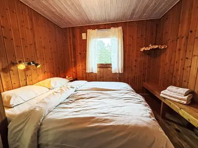 a bed in a wooden room with a window at Holiday Home Turken by Interhome in Kaupanger