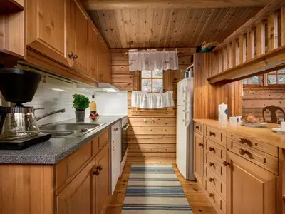 a kitchen with wooden cabinets and a refrigerator at Chalet Fjordblick I by Interhome in Olden