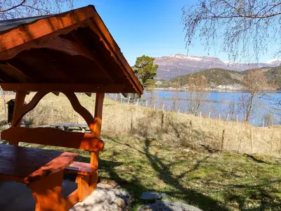 a picnic table with a view of a lake at Holiday Home Rabbane by Interhome in Nyttingsnes