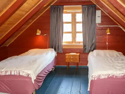 two beds in a attic room with a window at Holiday Home Rabbane by Interhome in Nyttingsnes