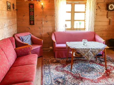 a living room with two red couches and a table at Holiday Home Rabbane by Interhome in Nyttingsnes