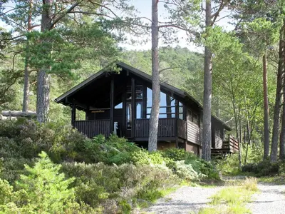 a log cabin in the woods with trees at Holiday Home Sandvikfjellet by Interhome in Nyttingsnes