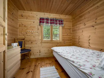 a bedroom with a bed in a wooden room at Holiday Home Myravatnet by Interhome in Viksdalen
