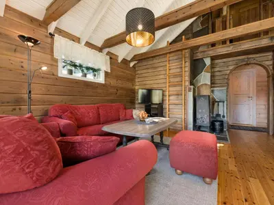 a living room with a red couch and a table at Holiday Home Strandbu by Interhome in Viksdalen