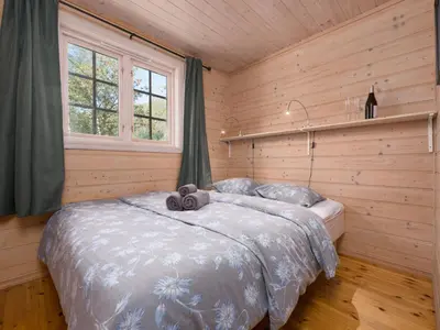 a bedroom with a bed in a wooden room at Holiday Home Strandbu by Interhome in Viksdalen