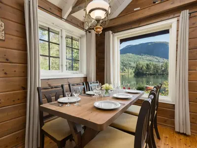 a dining room with a table and chairs and a large window at Holiday Home Strandbu by Interhome in Viksdalen
