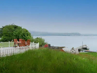 a deck with chairs sitting on it next to a body of water at Holiday Home Havsblikk by Interhome in England