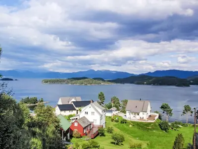 a group of houses on a hill next to a body of water at Apartment Galanten by Interhome in Lunde