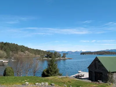 a black barn on the shore of a lake at Apartment Galanten by Interhome in Lunde