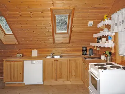 a kitchen in a log cabin with a sink and a stove at Holiday Home Tufto by Interhome in Lunde