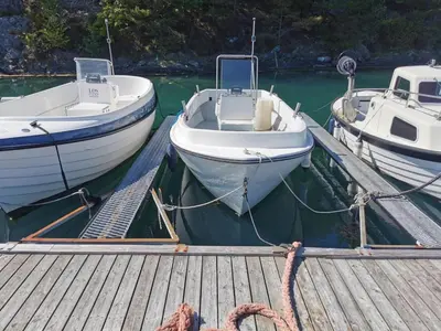 three boats are docked at a dock in the water at Holiday Home Blåbærhytta by Interhome in Onarheim