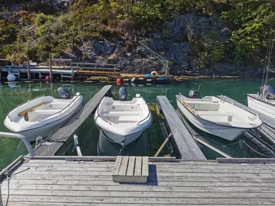 three boats are docked at a dock in the water at Holiday Home Blåbærhytta by Interhome in Onarheim