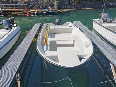 a small boat is docked at a dock at Holiday Home Blåbærhytta by Interhome in Onarheim