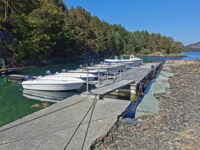 a group of boats docked at a dock in the water at Holiday Home Blåbærhytta by Interhome in Onarheim