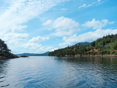 a view of a lake with a house on the shore at Holiday Home Tyttebærhytta by Interhome in Onarheim