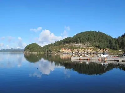 a large body of water with a pier and trees at Apartment Rorbuen by Interhome in Uggdal