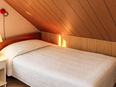 a bedroom with a white bed with a wooden ceiling at Holiday Home Bjørkeneset by Interhome in Uggdal
