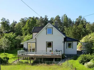 a small white house with a large porch at Holiday Home Bjørkeneset by Interhome in Uggdal