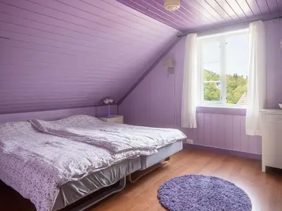 a purple bedroom with a bed and a window at Chalet Gulehuset by Interhome in Gjelland