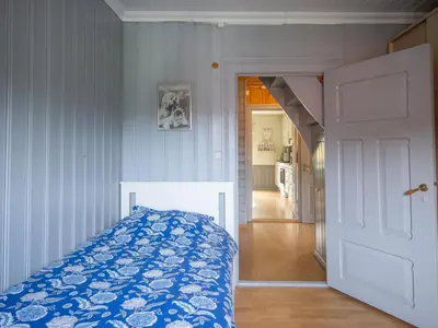 a bedroom with a bed with a blue and white comforter at Chalet Gulehuset by Interhome in Gjelland
