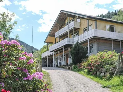 a house on a dirt road with flowers at Holiday Home Gule huset by Interhome in Bruntveit
