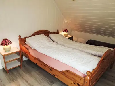 a bedroom with a wooden bed with two night stands at Holiday Home Gamlahuset by Interhome in Bruntveit