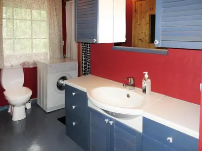 a bathroom with a sink and a washing machine at Chalet Anna by Interhome in Eikelandsosen