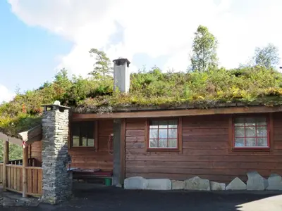 a log cabin with plants on the roof at Chalet Anna by Interhome in Eikelandsosen